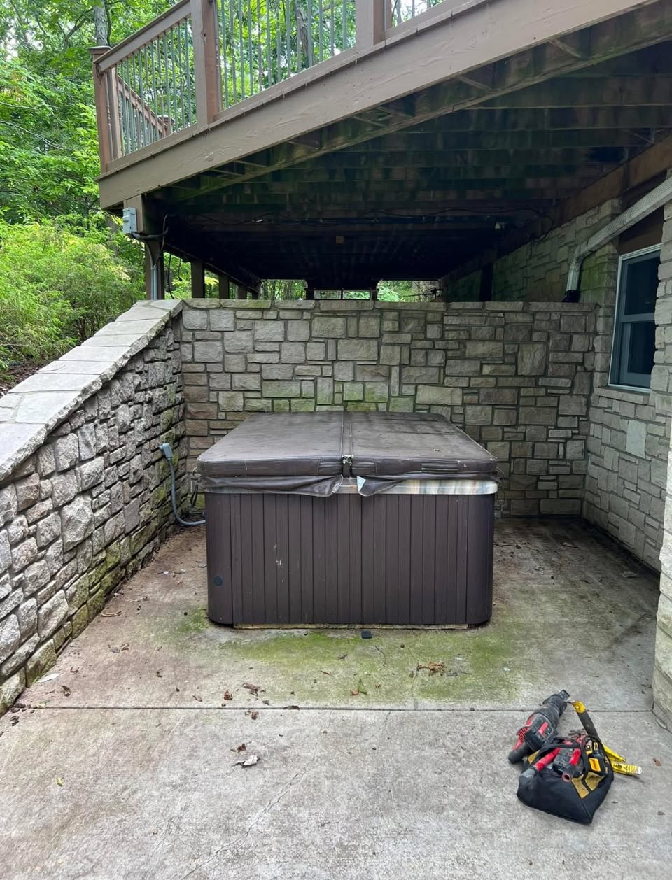 Old hot tub beneath a raised wooden deck
